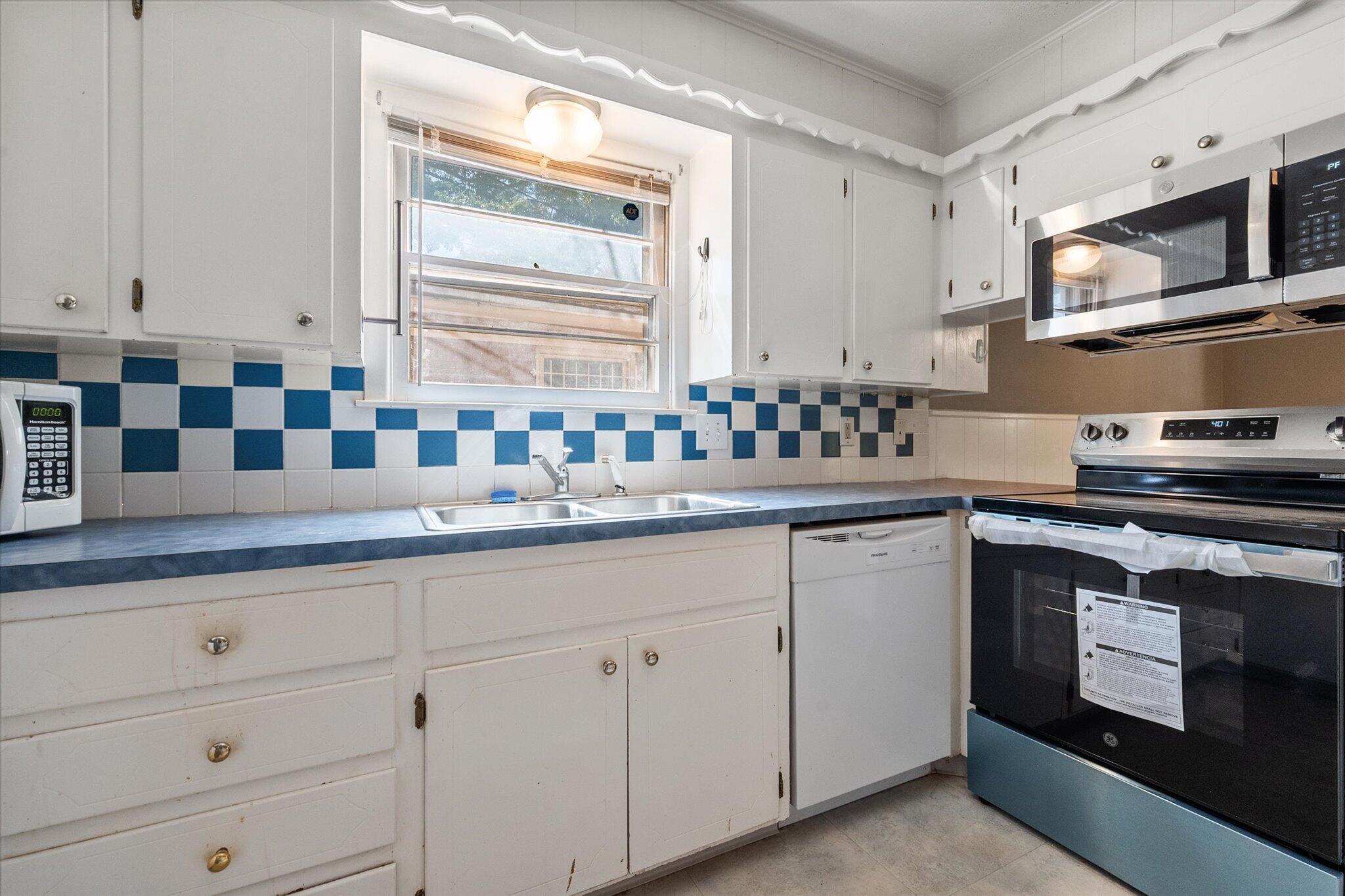 4604 27th Street Lubbock, TX 79410 - Photo 27 of 36 a kitchen with granite countertop white cabinets and white appliances