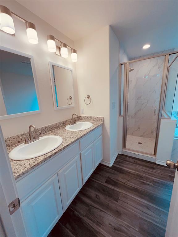 103 East 15th Street Bonham, TX 75418 - Photo 10 of 17 a bathroom with a double vanity sink and mirror