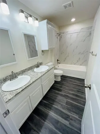 a bathroom with a double vanity sink and a mirror