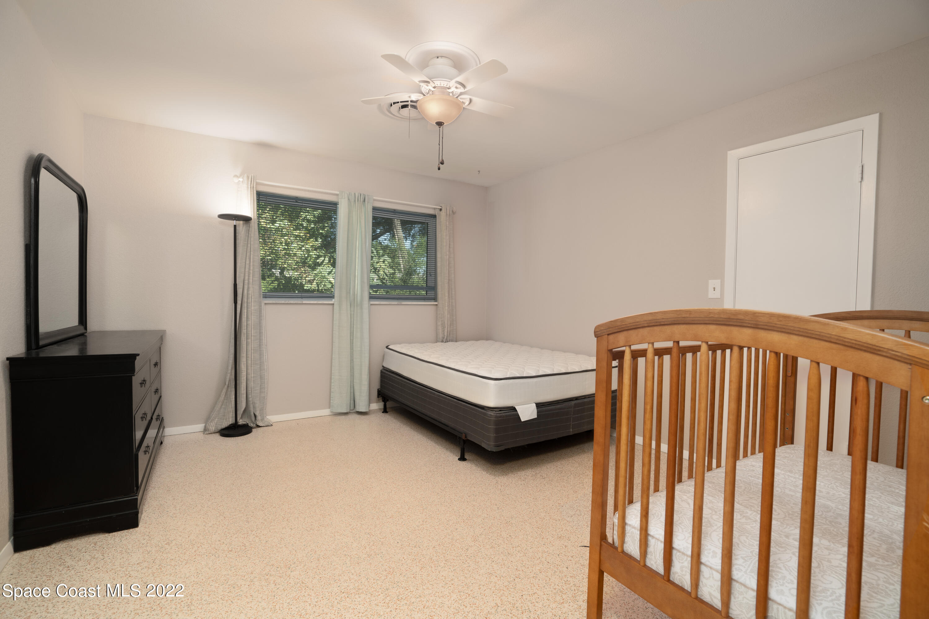 111 Highview Drive Cocoa, FL 32922 - Photo 12 of 17 a bedroom with a bed and a chandelier