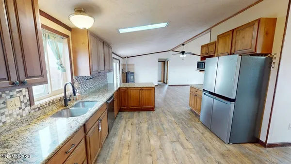 a kitchen with granite countertop a sink stove and refrigerator