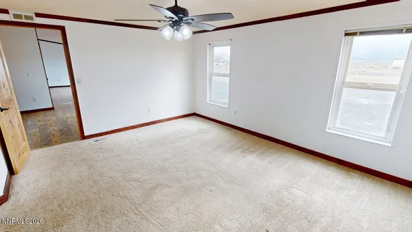 a view of empty room with a ceiling fan and a window