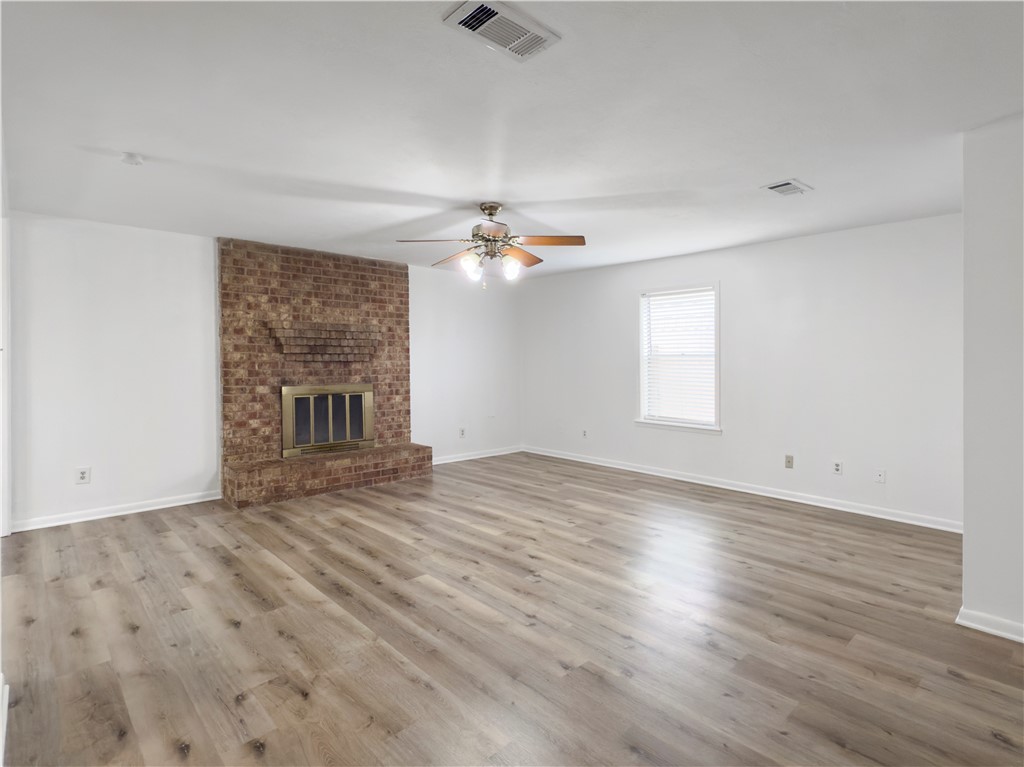 3234 Red Robin Loop Bryan, TX 77802 - Photo 4 of 19 an empty room with wooden floor fireplace and windows