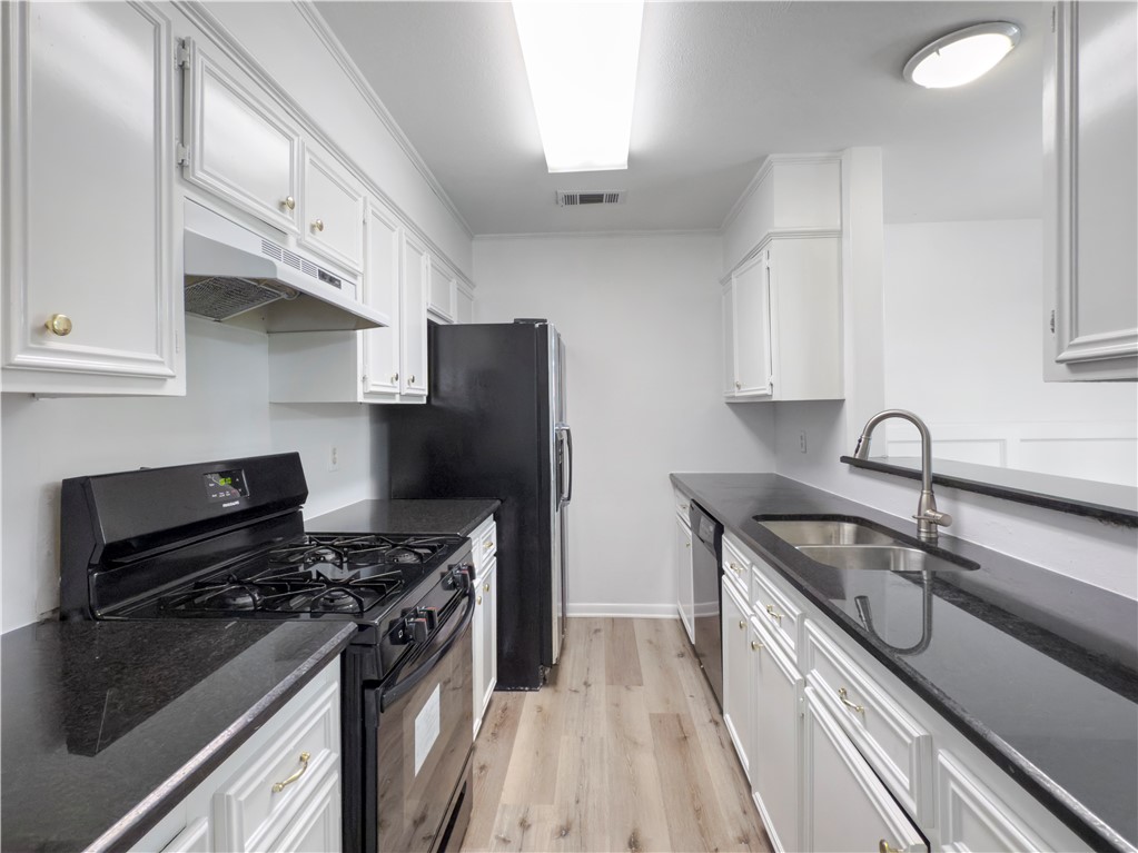 3234 Red Robin Loop Bryan, TX 77802 - Photo 6 of 19 a kitchen with stainless steel appliances granite countertop a sink stove and refrigerator