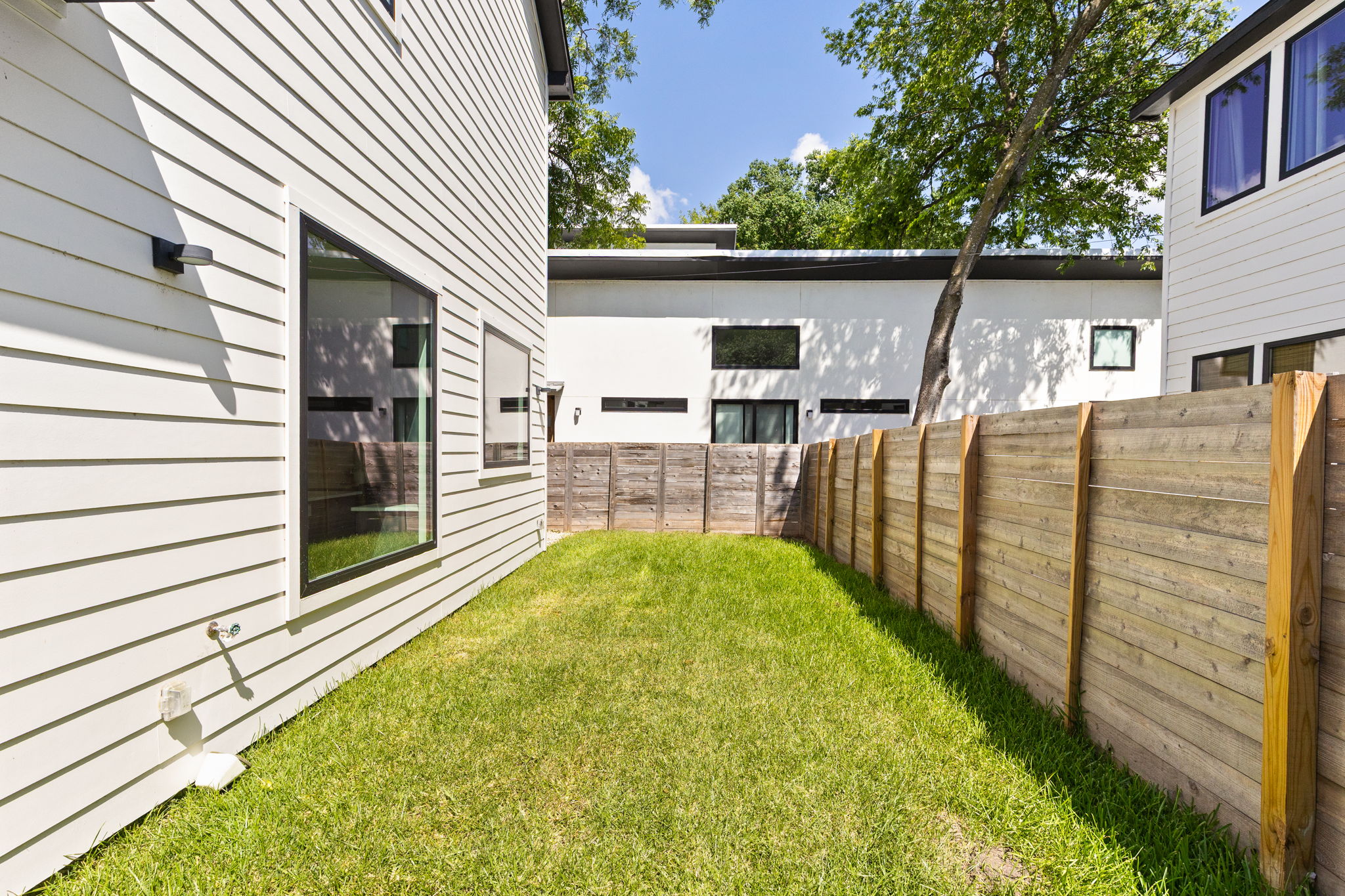 2717 Lyons Road, Unit 1 Austin, TX 78702 - Photo 17 of 40 A fenced backyard space provides a private green retreat between modern residential structures.