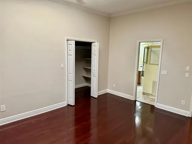 an empty room with wooden floor and closet
