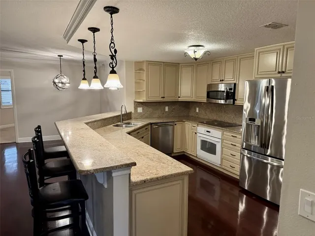 a kitchen with a sink a kitchen island and stainless steel appliances