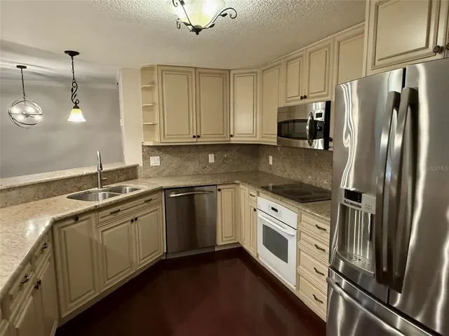 a kitchen with stainless steel appliances a refrigerator sink and microwave