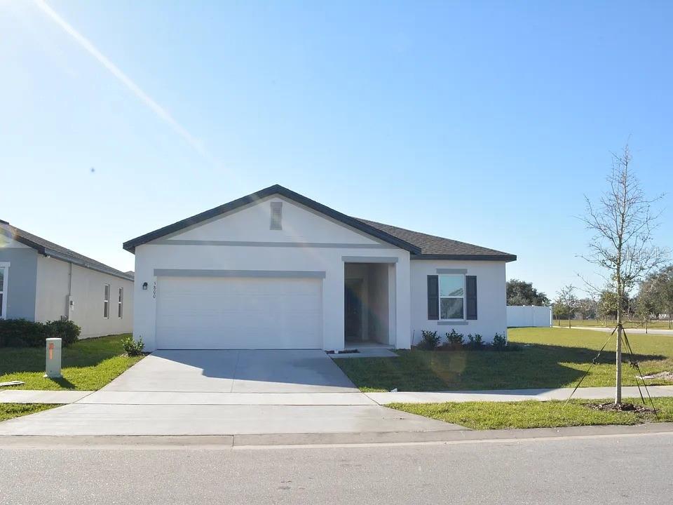 5800 Bullock Place St. Cloud, FL 34771 - Photo 1 of 4 a front view of a house with a yard and garage
