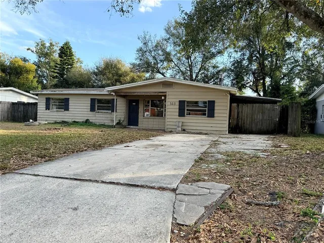 a front view of house with yard and trees all around