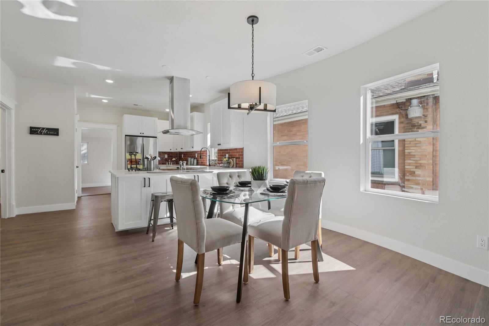 2342 Dexter Street Denver, CO 80207 - Photo 11 of 50 a dining room with wooden floor a chandelier a glass table and chairs
