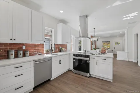 a kitchen with stainless steel appliances granite countertop a sink stove and white cabinets