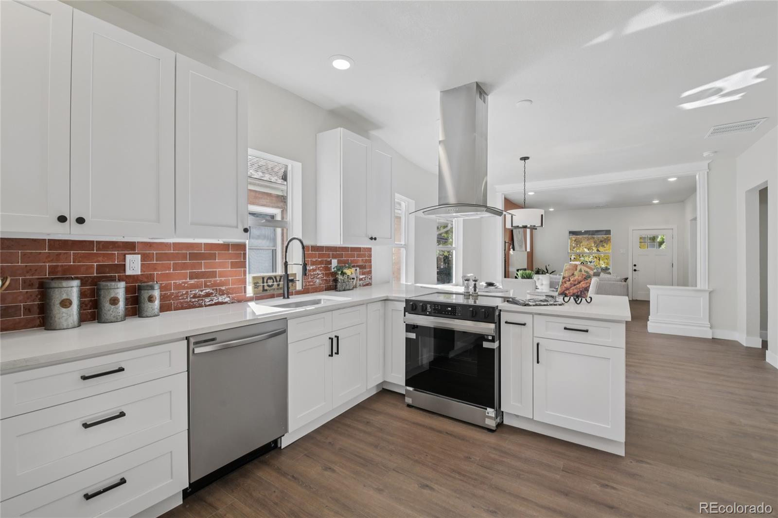 2342 Dexter Street Denver, CO 80207 - Photo 13 of 50 a kitchen with stainless steel appliances granite countertop a sink stove and white cabinets