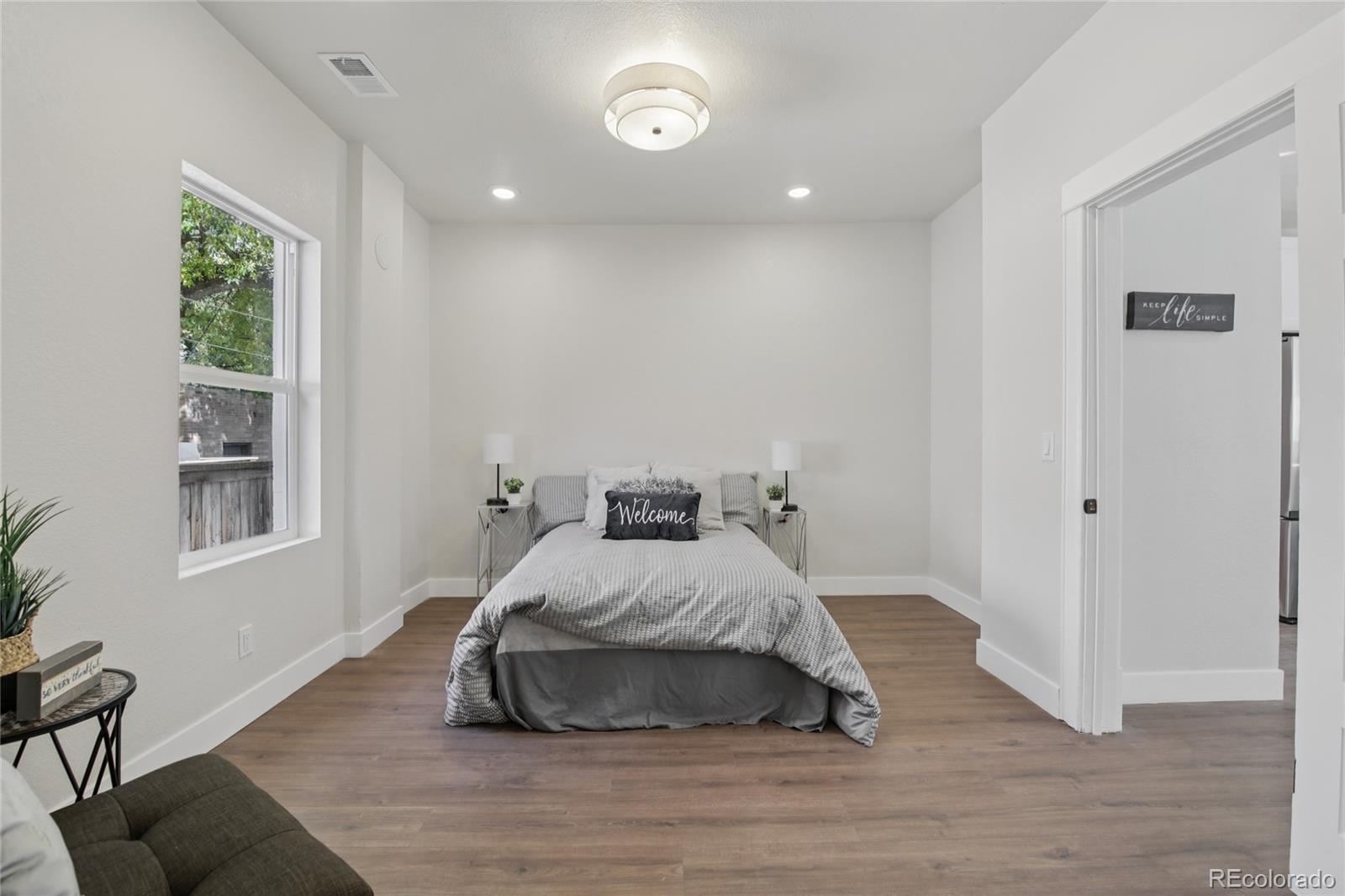 2342 Dexter Street Denver, CO 80207 - Photo 23 of 50 a bedroom with a bed and wooden floor