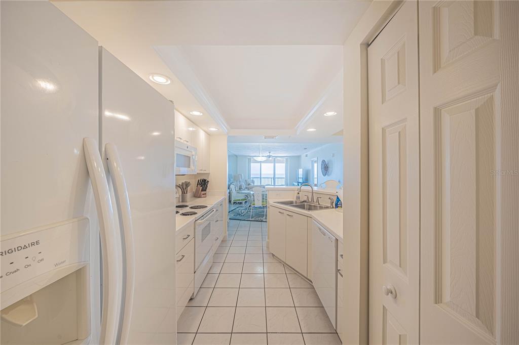 4575 South Atlantic Avenue, Unit 6607 Ponce Inlet, FL 32127 - Photo 15 of 48 a large white kitchen with a sink a refrigerator and a stove