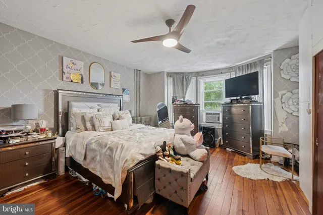 a bedroom with a bed furniture and a flat tv screen