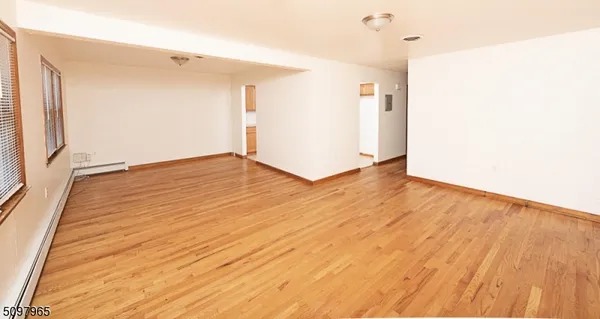 a view of an empty room with wooden floor