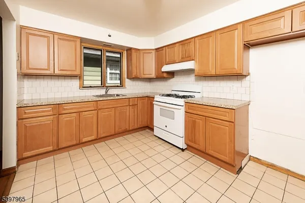 a kitchen with stainless steel appliances granite countertop a stove sink and cabinets