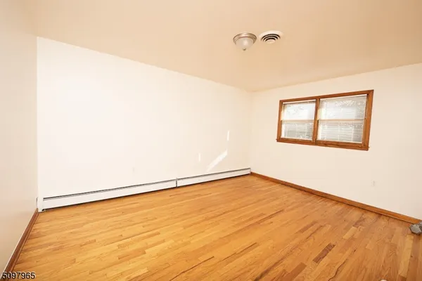 a view of a room with wooden floor and a window