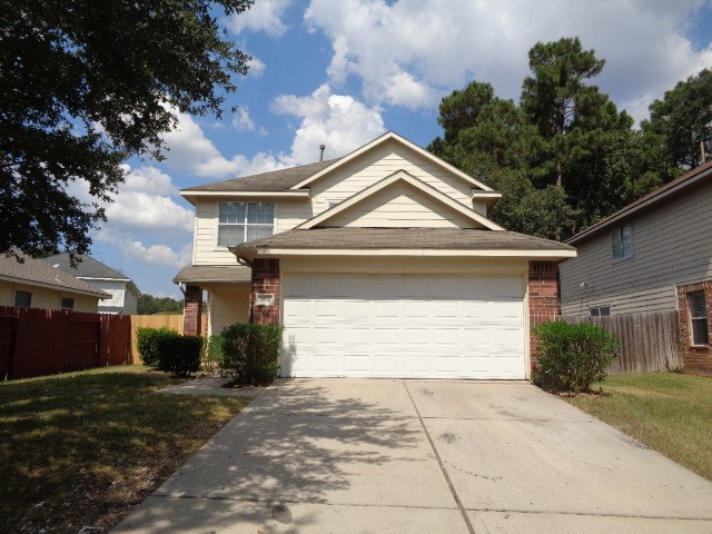 1615 Redbud Grove Court Conroe, TX 77301 - Photo 1 of 20 a front view of a house with a yard and garage