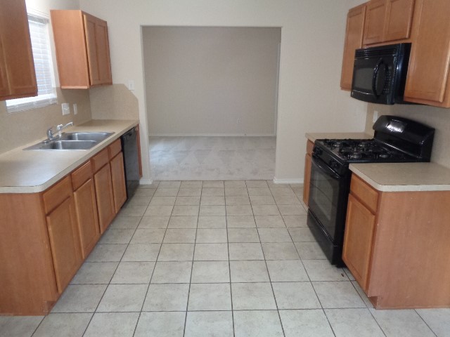 1615 Redbud Grove Court Conroe, TX 77301 - Photo 2 of 20 a kitchen with a sink a stove and a microwave