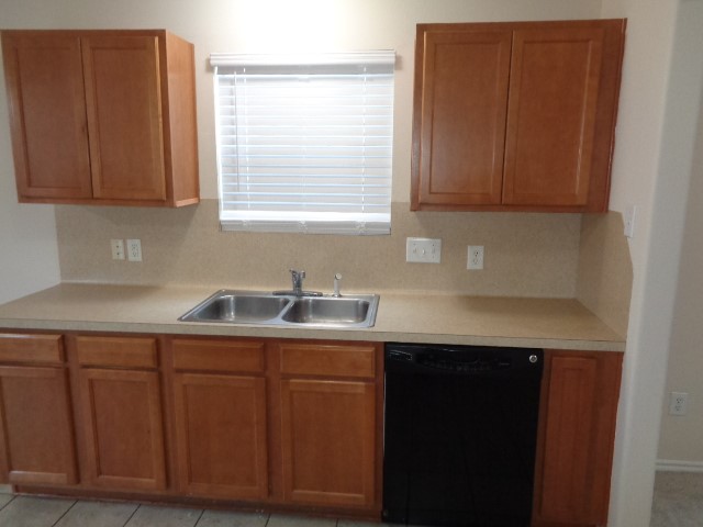 1615 Redbud Grove Court Conroe, TX 77301 - Photo 4 of 20 a kitchen with a sink cabinets and window