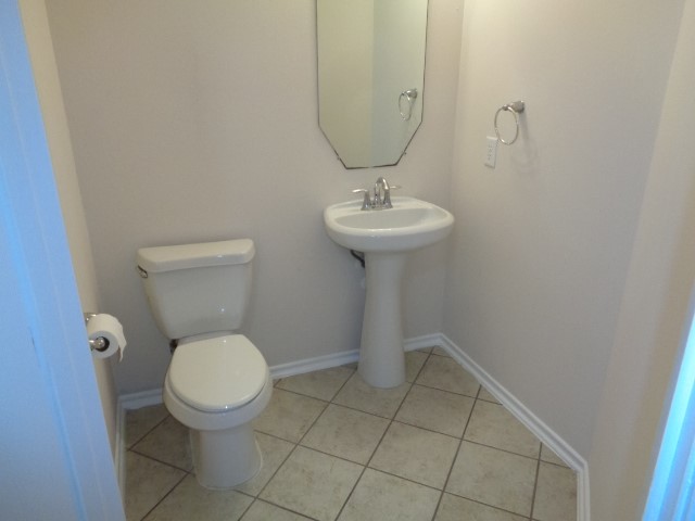 1615 Redbud Grove Court Conroe, TX 77301 - Photo 7 of 20 a bathroom with a toilet sink and mirror