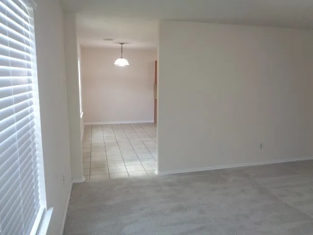 a view of an empty room with closet and a window