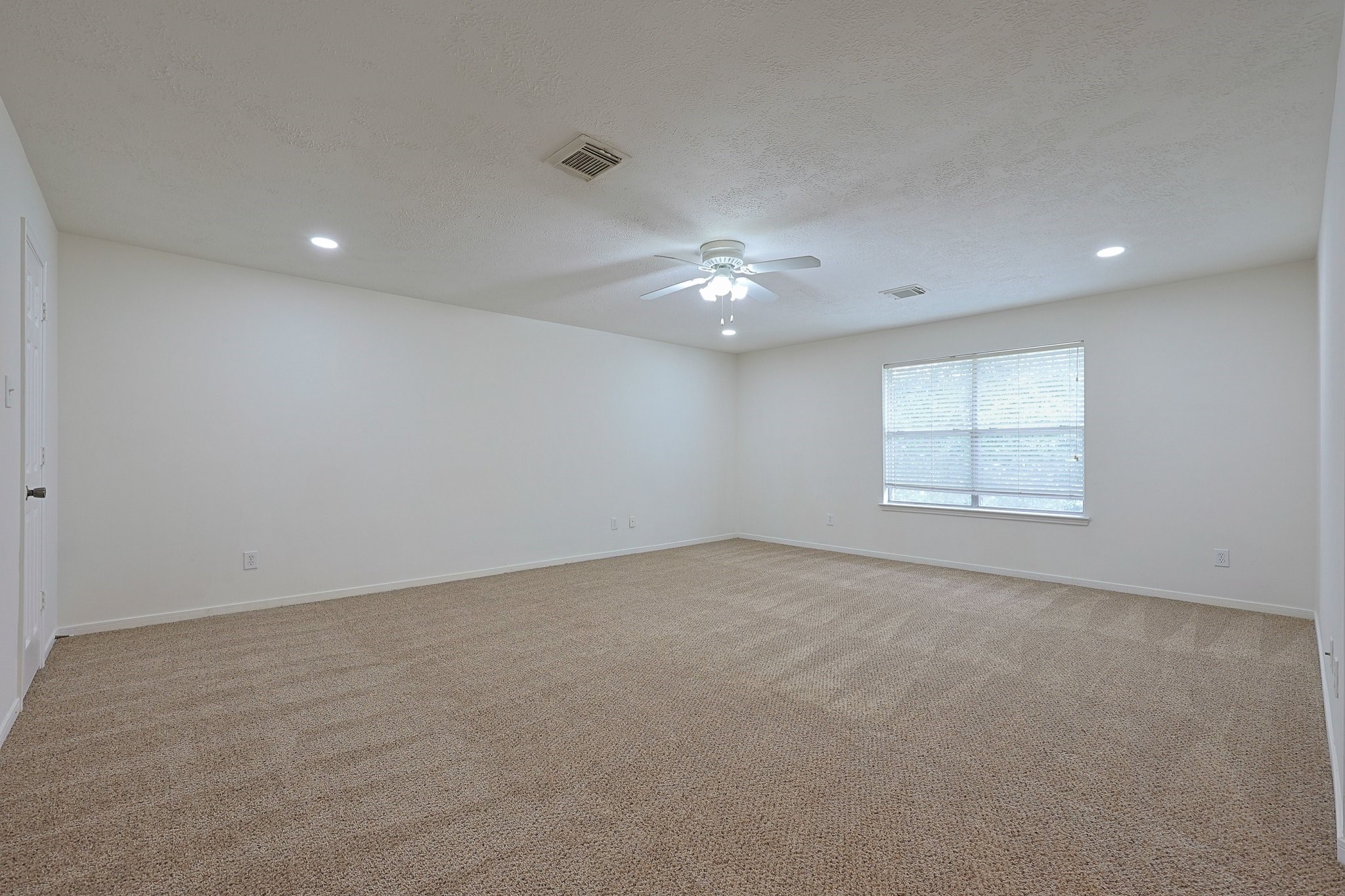 23019 Eastgate Village Drive Spring, TX 77373 - Photo 30 of 46 This spacious room features neutral carpeting, white walls, and recessed lighting. A ceiling fan provides comfort, and a large window allows natural light to brighten the space, perfect for a cozy living area or versatile use.