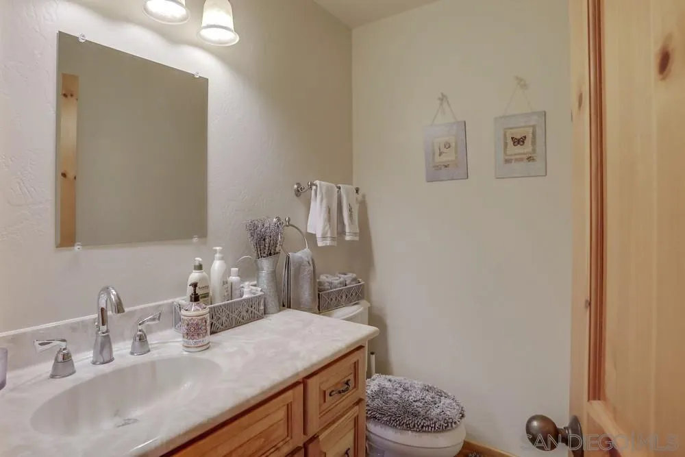 753 Ridgewood Drive Julian, CA 92036 - Photo 14 of 48 a bathroom with a granite countertop sink a toilet and a mirror
