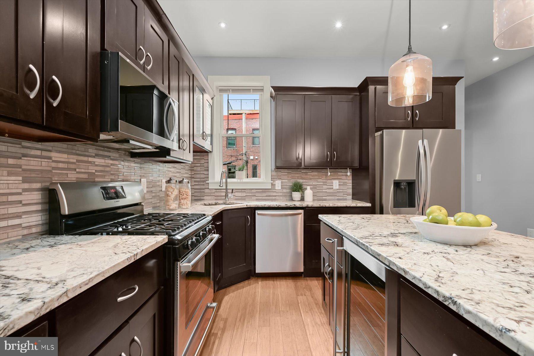2128 1st Street Northwest, Unit 1 Washington, DC 20001 - Photo 12 of 36 a kitchen with stainless steel appliances granite countertop a sink stove and refrigerator