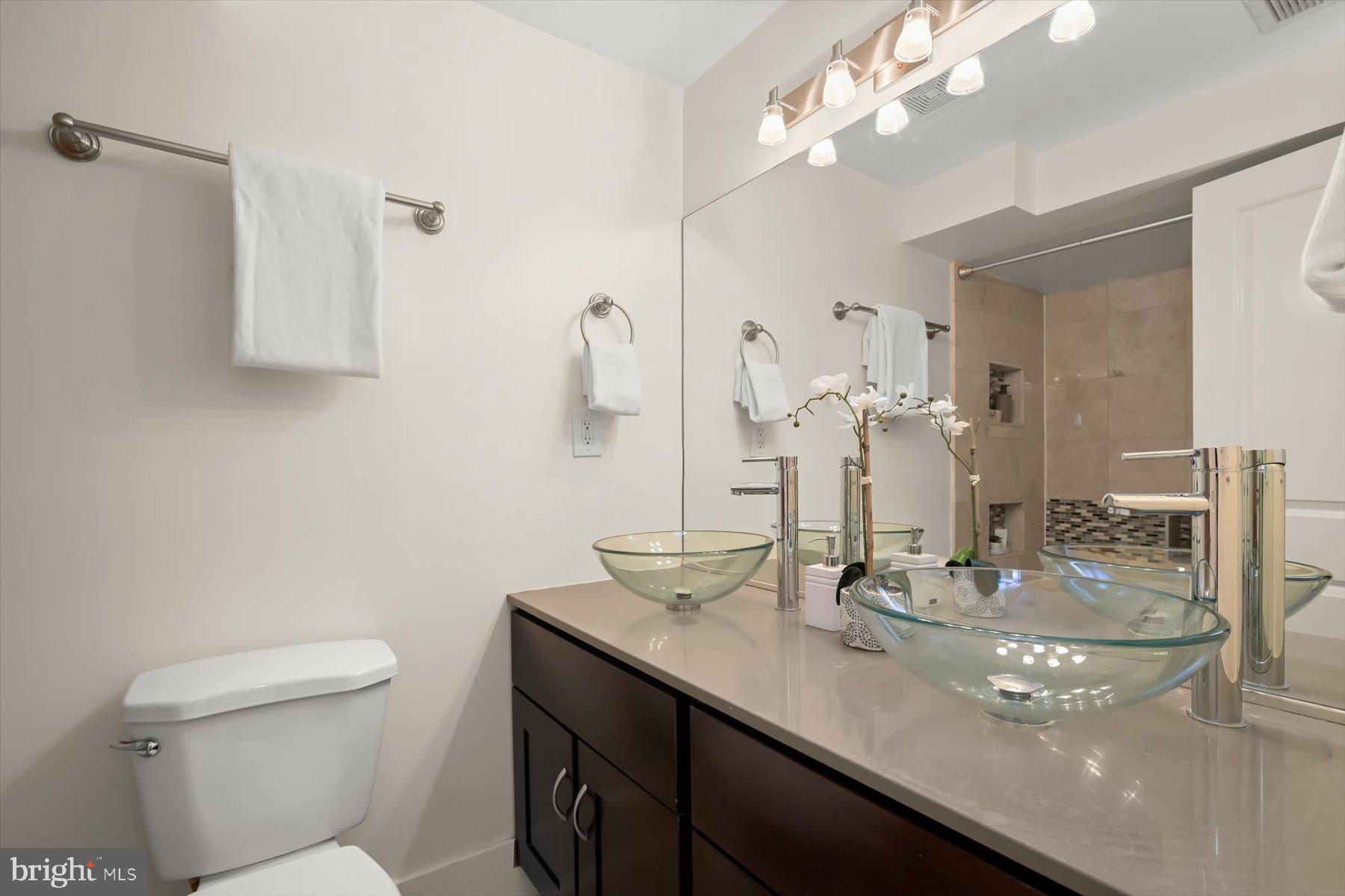 2128 1st Street Northwest, Unit 1 Washington, DC 20001 - Photo 26 of 36 a bathroom with a granite countertop sink a toilet and a mirror