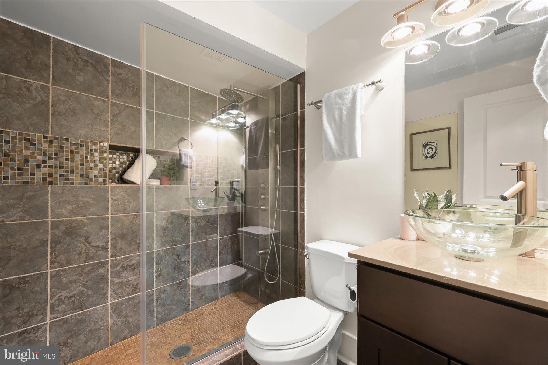 2128 1st Street Northwest, Unit 1 Washington, DC 20001 - Photo 30 of 36 a bathroom with a sink a toilet a mirror and shower