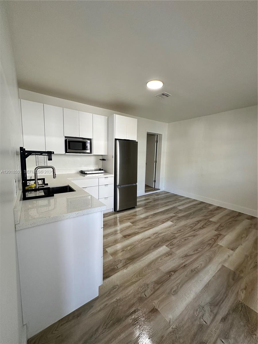 111 Southwest 31st Court Miami, FL 33135 - Photo 15 of 27 a kitchen with kitchen island a stove a sink and a refrigerator