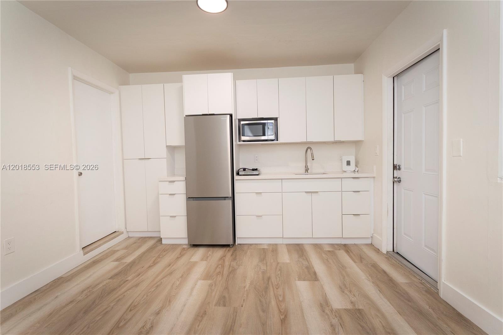 111 Southwest 31st Court Miami, FL 33135 - Photo 17 of 27 a kitchen with a refrigerator sink and cabinets