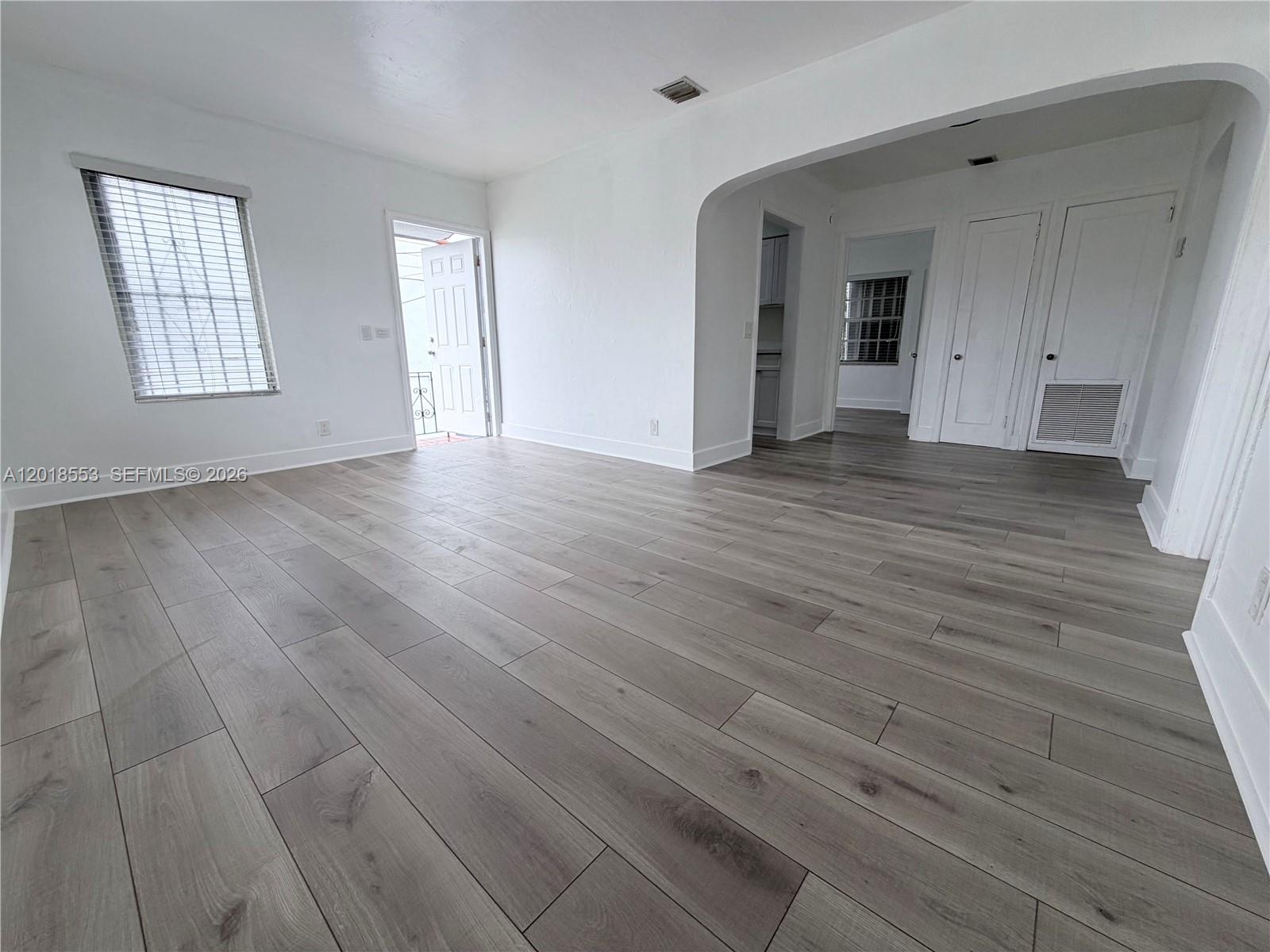 111 Southwest 31st Court Miami, FL 33135 - Photo 23 of 27 an empty room with wooden floor and windows