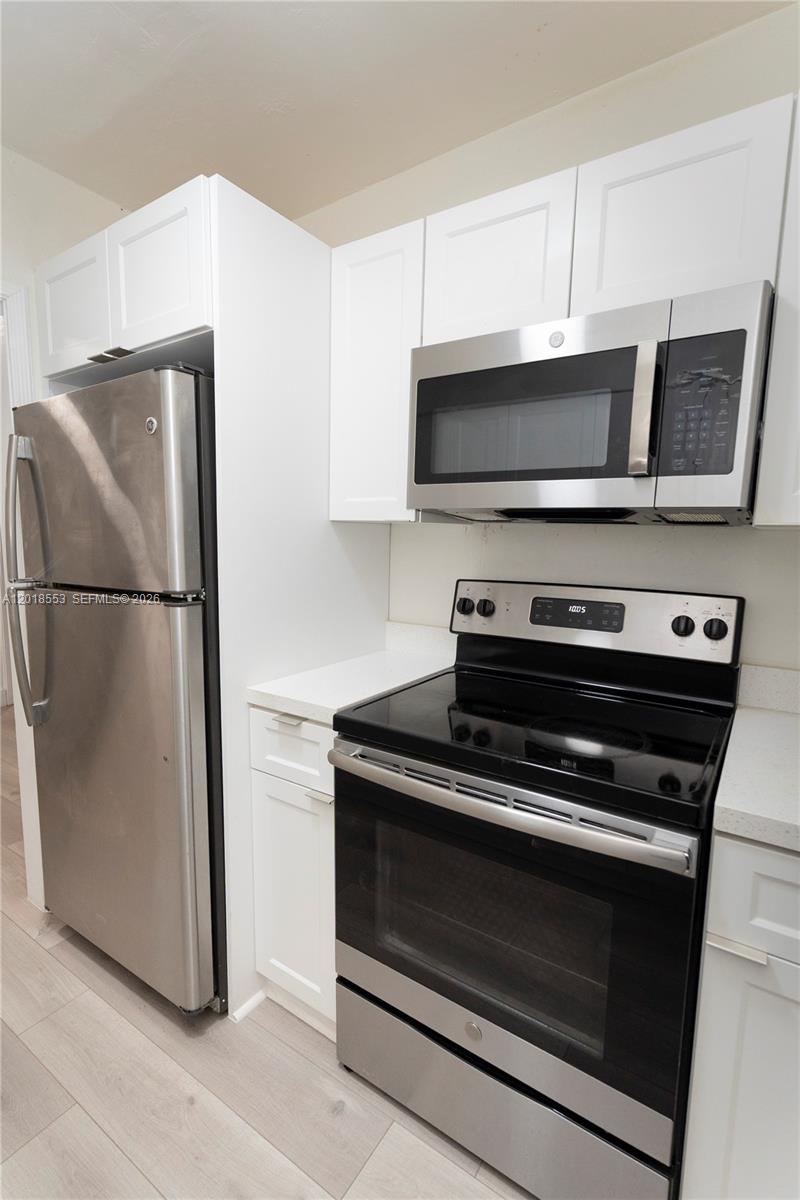 111 Southwest 31st Court Miami, FL 33135 - Photo 3 of 27 a kitchen with wooden cabinets and stainless steel appliances
