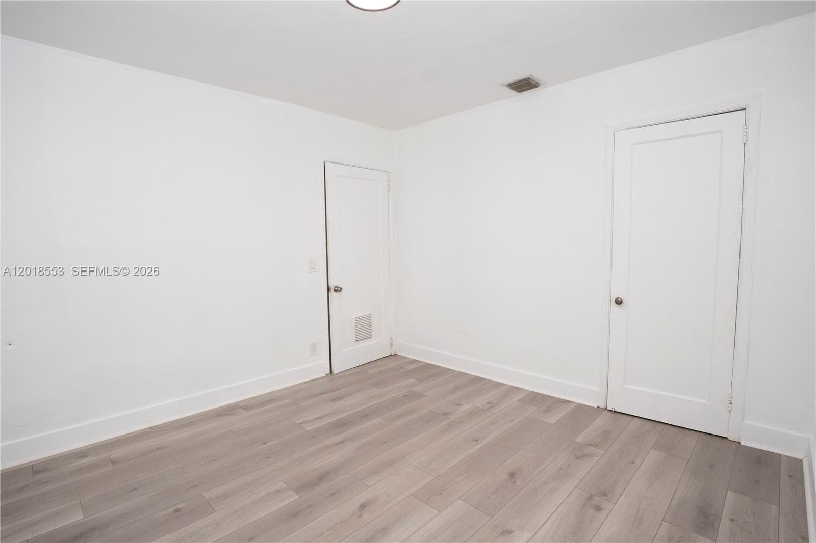 111 Southwest 31st Court Miami, FL 33135 - Photo 7 of 27 an empty room with wooden floor