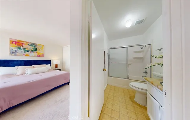 a bathroom with a granite countertop sink a toilet and shower