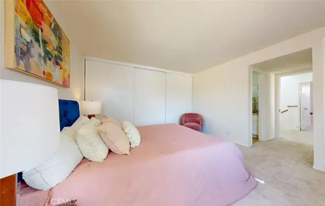 a bedroom with a bed and a painting on the wall