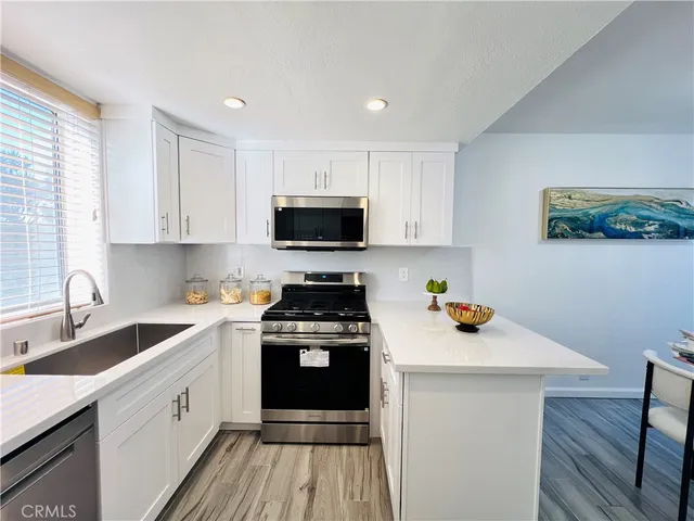 a kitchen with a sink a stove and cabinets