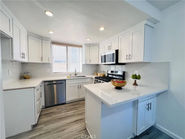 a kitchen with white cabinets and white appliances