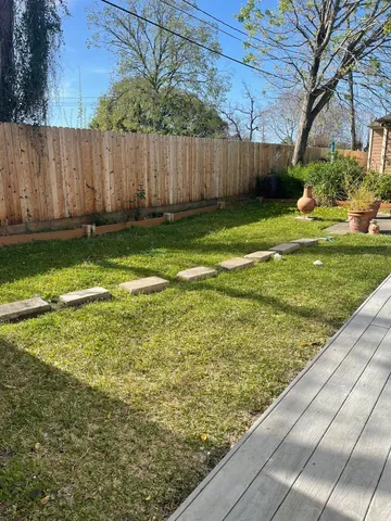 a view of a backyard with wooden fence