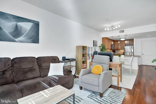 a living room with furniture a rug and kitchen view