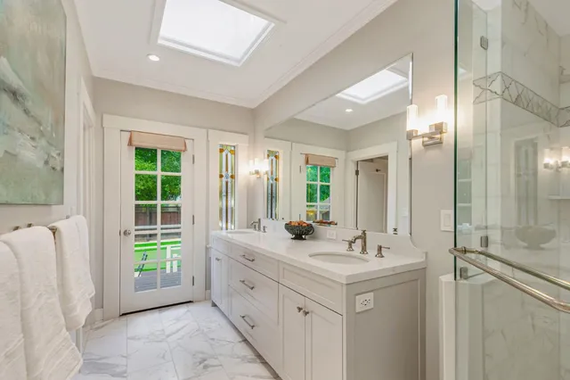 a bathroom with a double vanity sink toilet mirror and shower