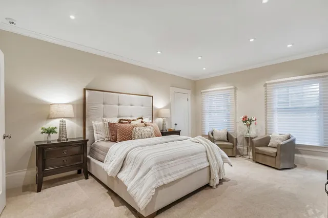 a spacious bedroom with a large bed and a painting on the wall