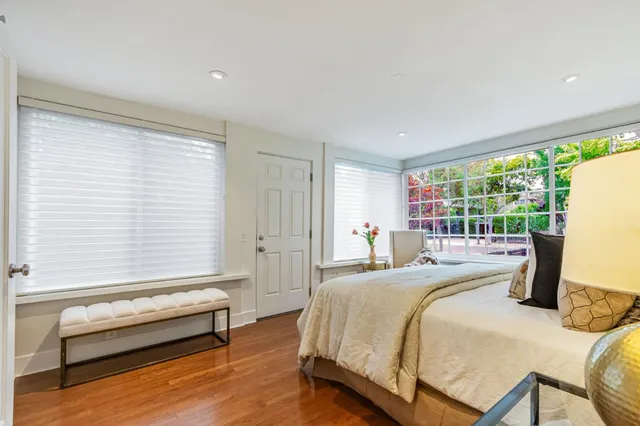 a bedroom with a bed table and a flat screen tv