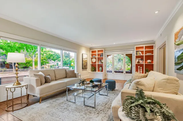 a view of a livingroom and dining room with furniture wooden floor a chandelier