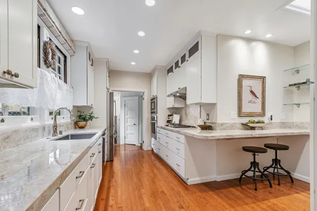 a kitchen with stainless steel appliances a stove sink and cabinets