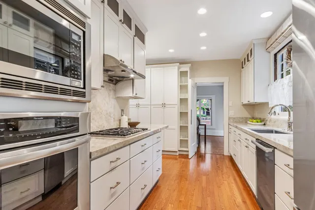 a kitchen with granite countertop sink stove and refrigerator